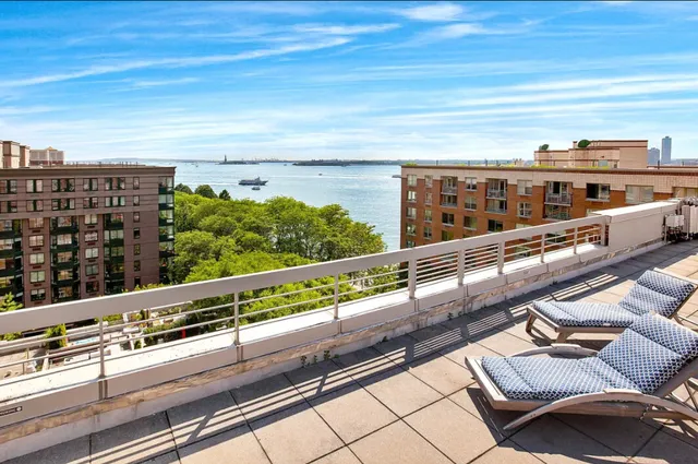 a view of a chairs and bench on the roof deck