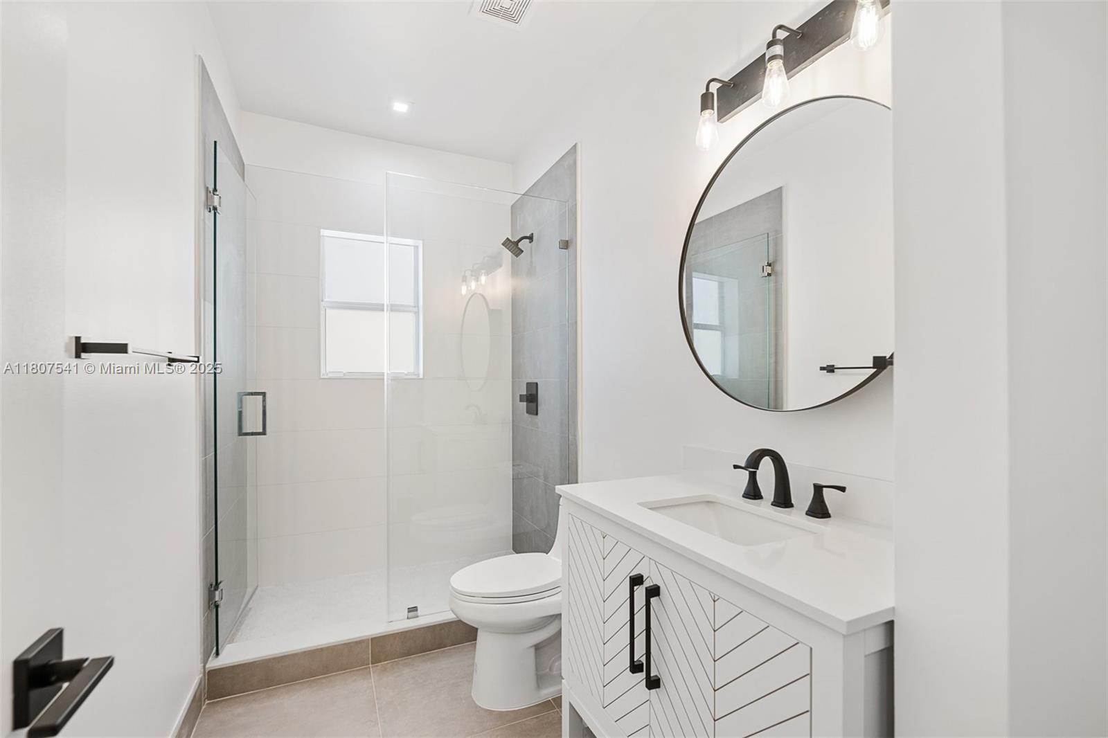 403 Southwest 12th Avenue, Unit 4 Miami, FL 33130 - Photo 14 of 24 a bathroom with a sink a toilet and a mirror