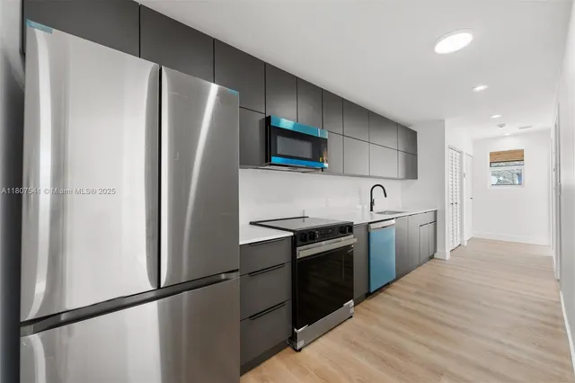 a kitchen with stainless steel appliances granite countertop a refrigerator and a stove top oven