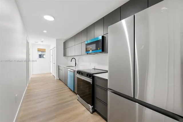 a kitchen with stainless steel appliances a refrigerator and a stove top oven