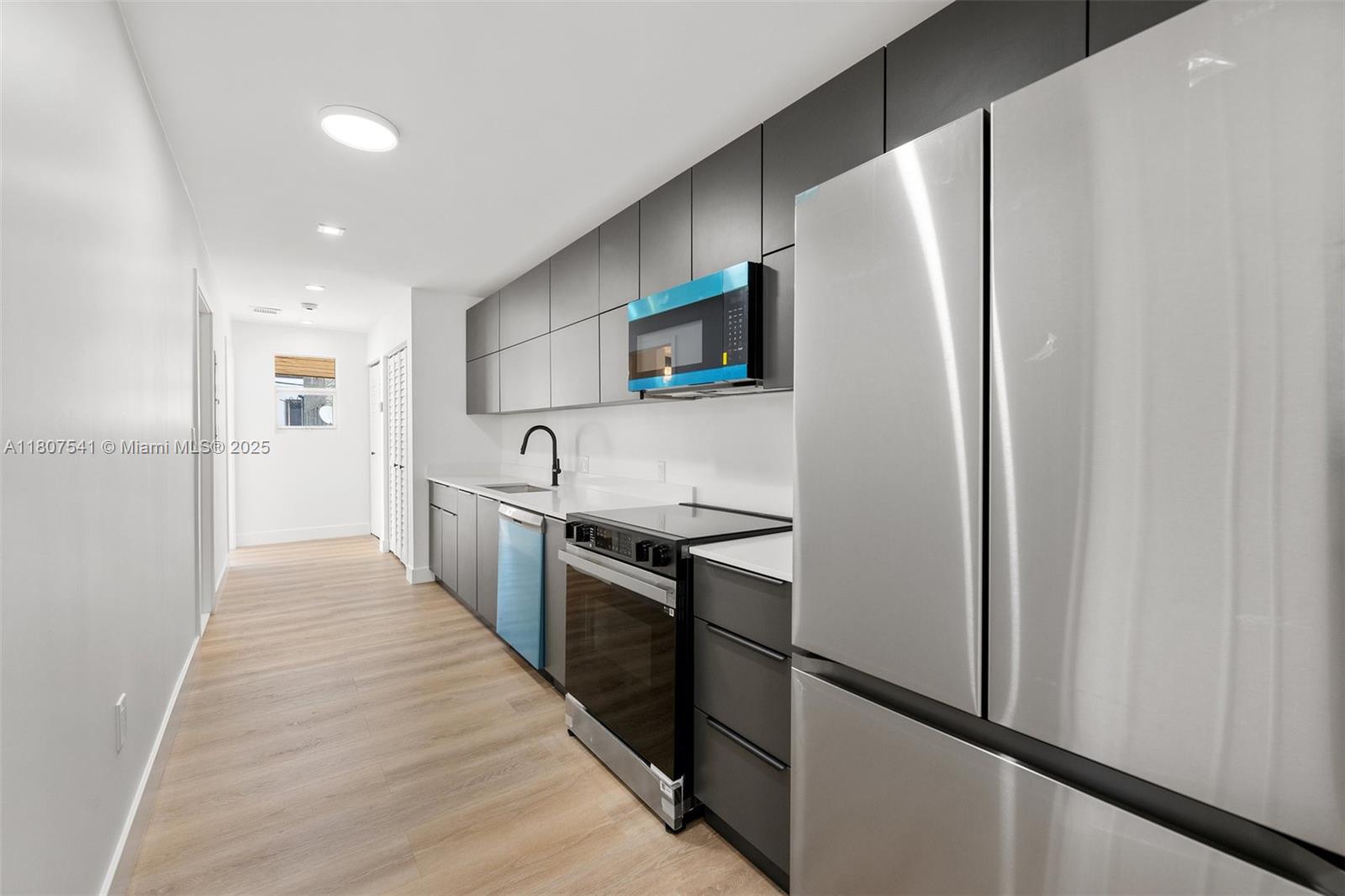 403 Southwest 12th Avenue, Unit 4 Miami, FL 33130 - Photo 4 of 24 a kitchen with stainless steel appliances a refrigerator and a stove top oven