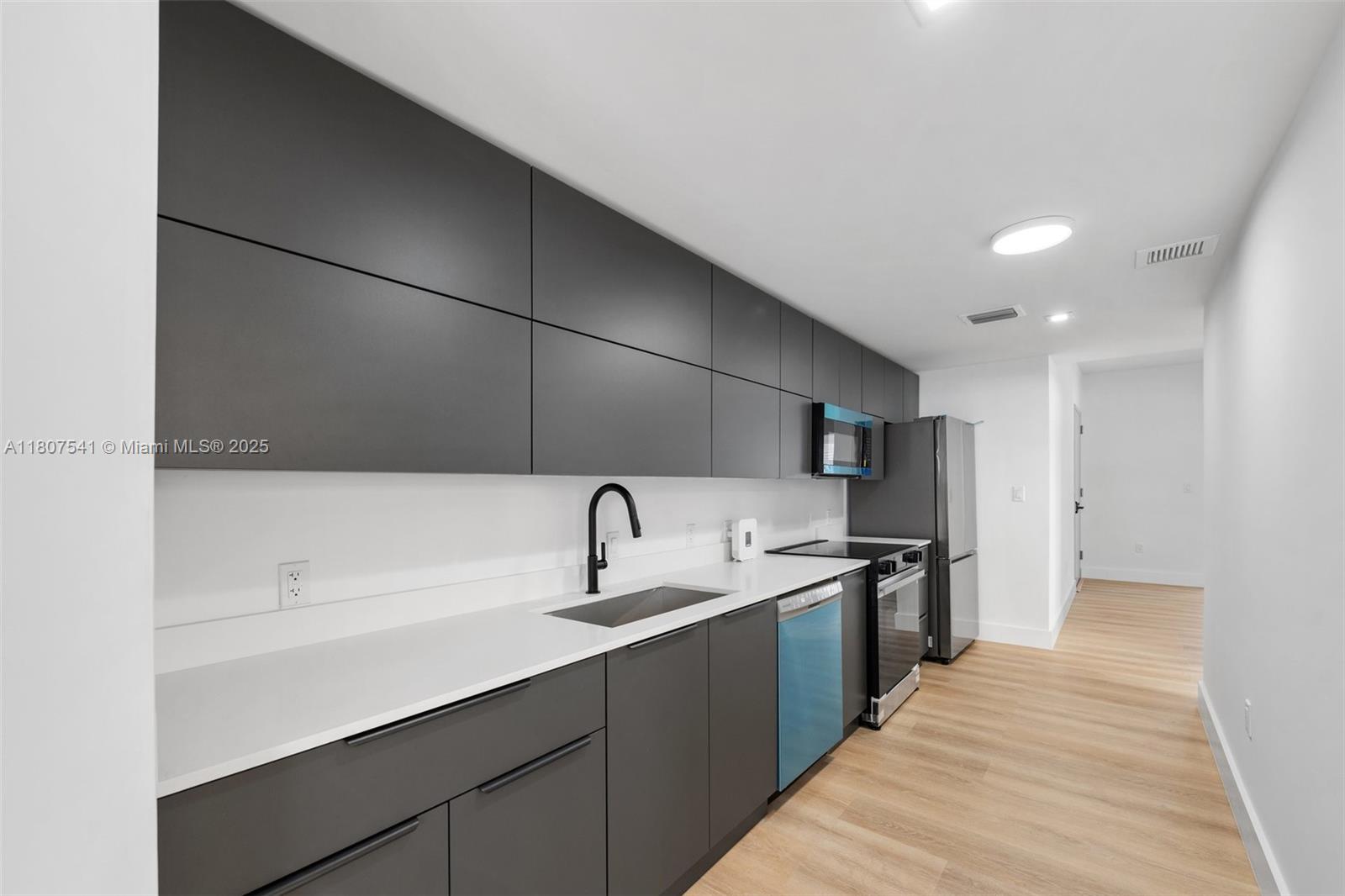 403 Southwest 12th Avenue, Unit 4 Miami, FL 33130 - Photo 5 of 24 a kitchen with stainless steel appliances granite countertop a sink and a stove