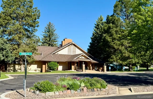 a living room with lots of furniture a rug a chandelier and windows