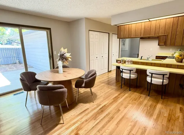 a kitchen with a table chairs and wooden floor