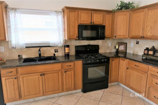 1516 Mayo Street Ridgecrest, CA 93555 - Photo 9 of 33 a kitchen with granite countertop white cabinets stainless steel appliances and a window