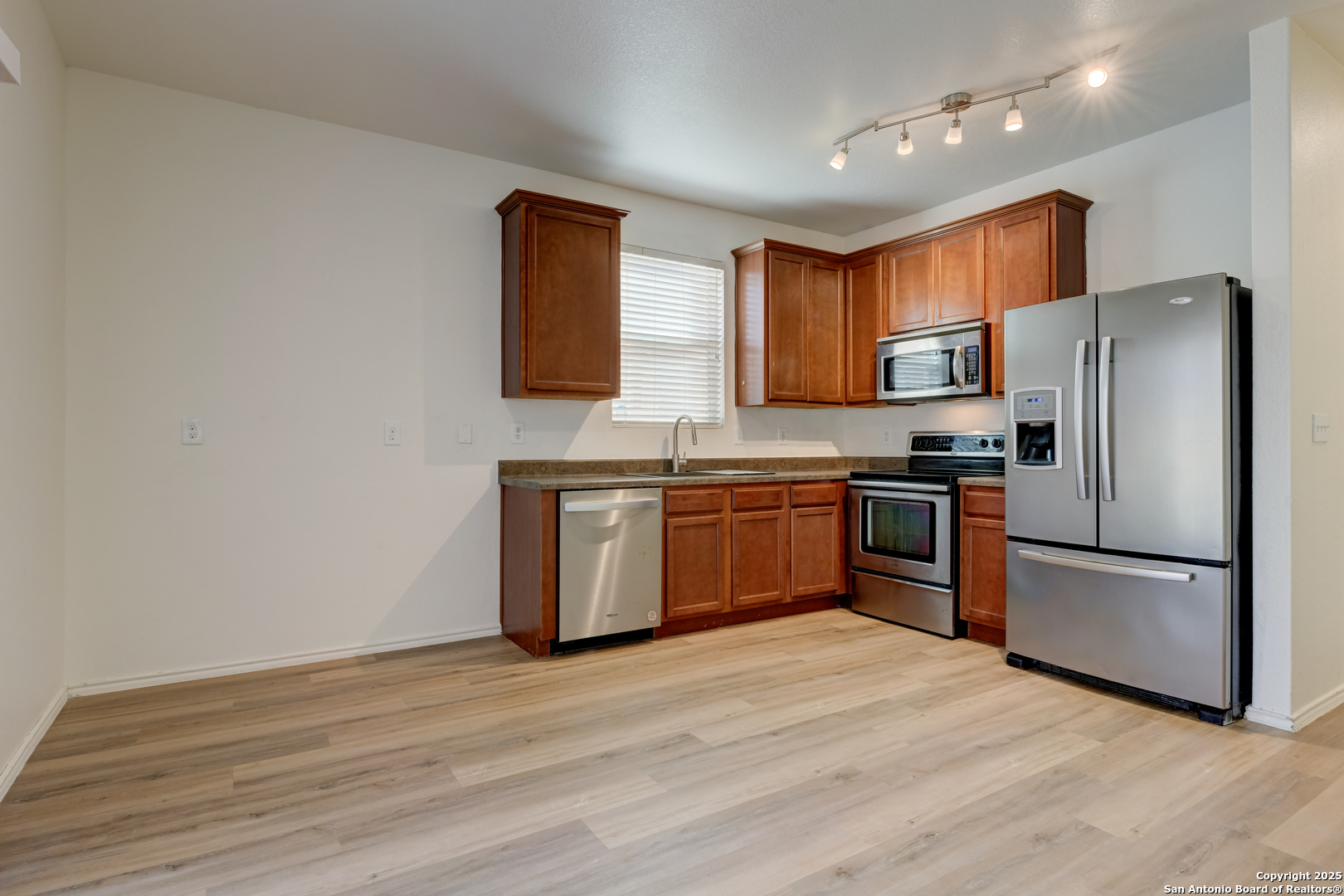 9447 Copper Mist Converse, TX 78109 - Photo 5 of 25 a kitchen with stainless steel appliances granite countertop a stove top oven a sink and a refrigerator