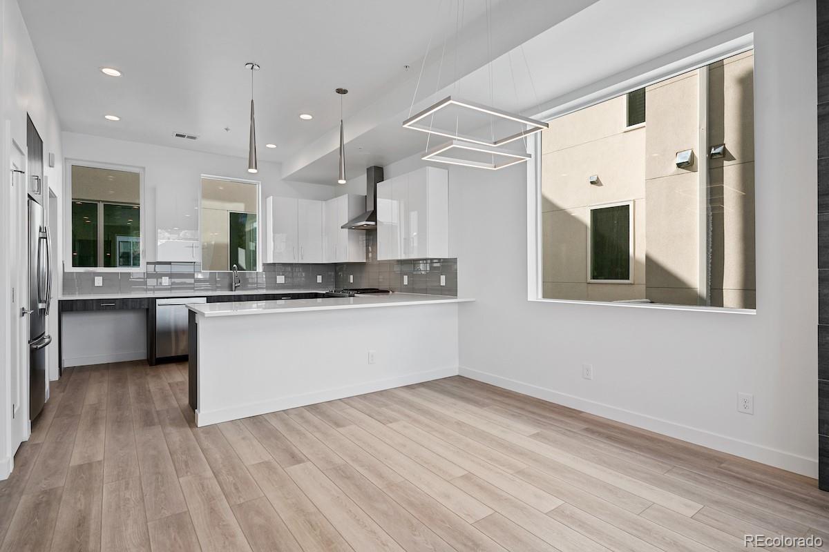 1624 Irving Street, Unit 1 Denver, CO 80204 - Photo 11 of 35 a large white kitchen with a large window stainless steel appliances and cabinets