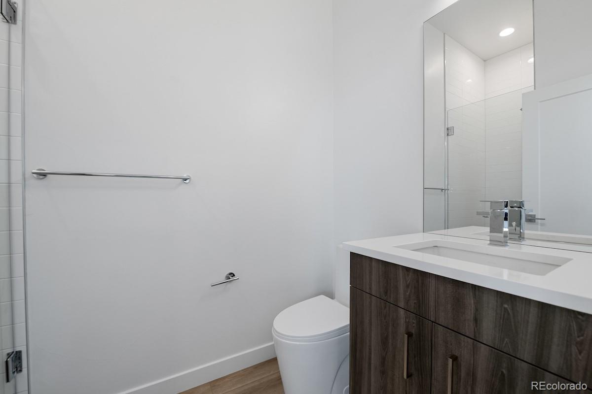 1624 Irving Street, Unit 1 Denver, CO 80204 - Photo 20 of 35 a bathroom with a granite countertop toilet and a sink