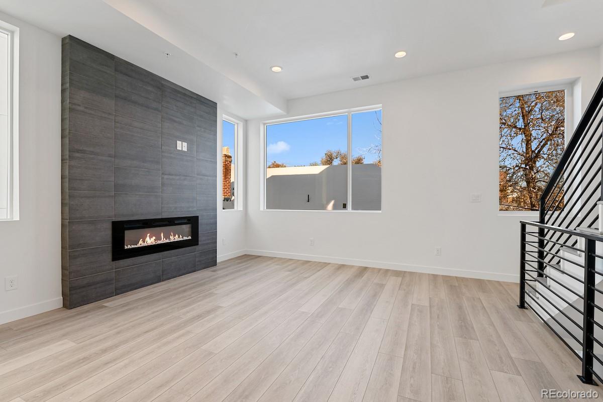 1624 Irving Street, Unit 1 Denver, CO 80204 - Photo 6 of 35 a view of a livingroom with wooden floor and a fireplace