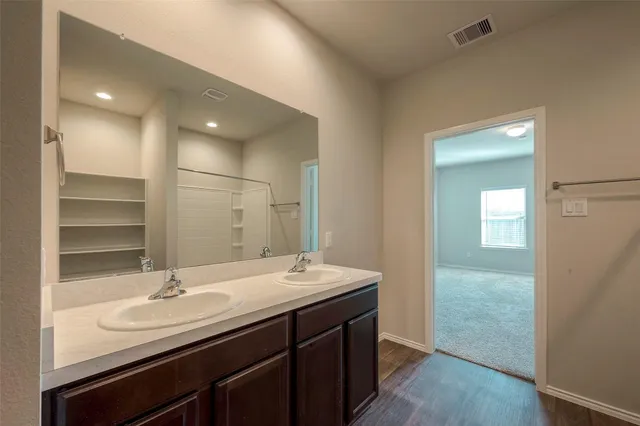 a bathroom with double sink and a mirror