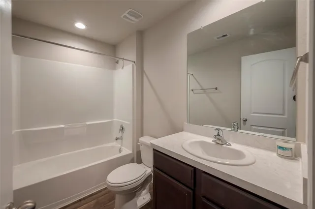 a bathroom with a sink toilet vanity and shower