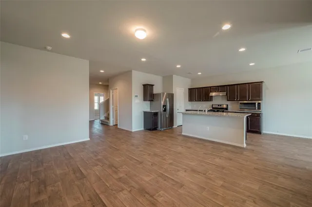 a view of kitchen with kitchen island a sink stainless steel appliances and cabinets