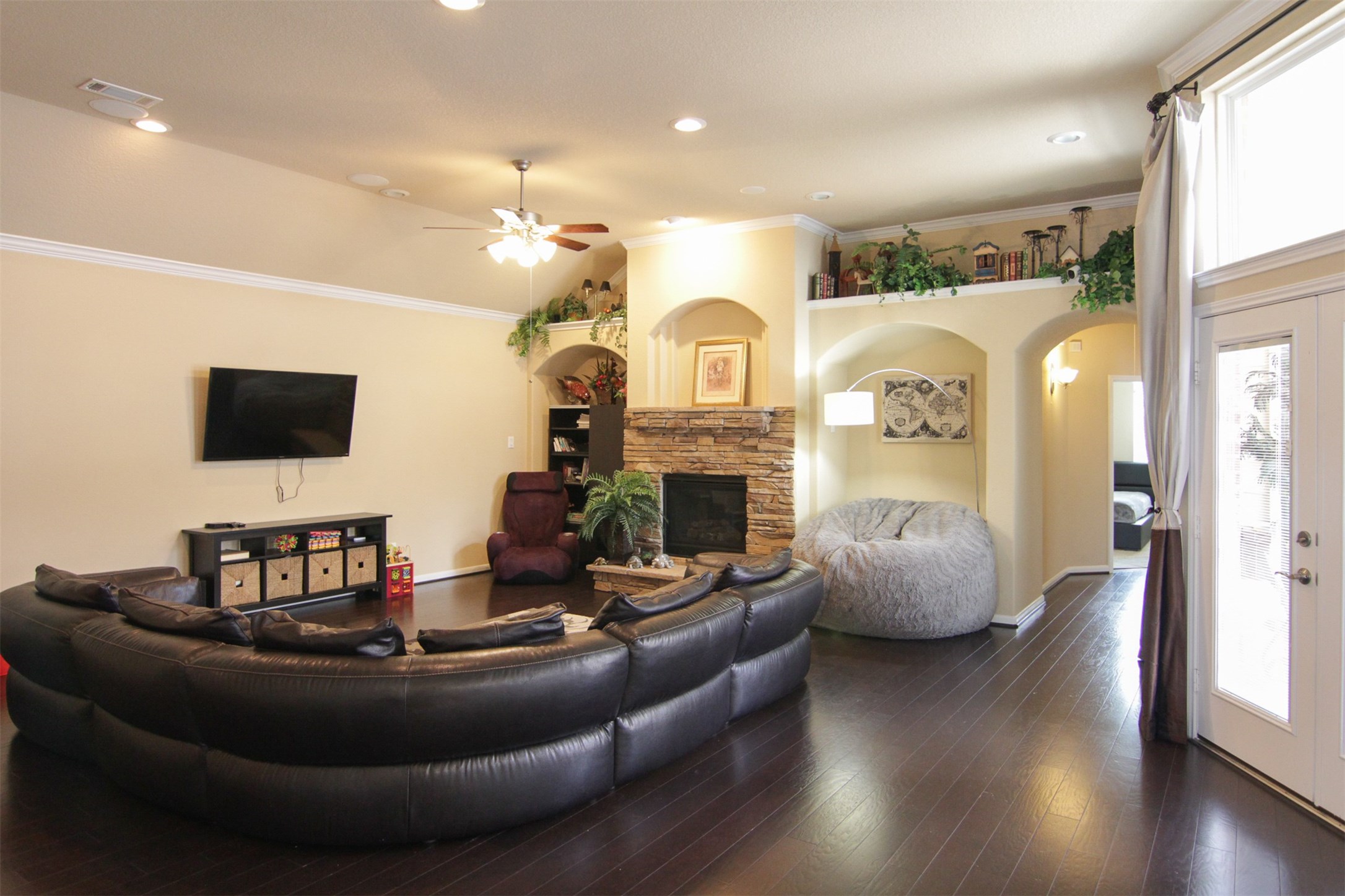 1423 Ralston Branch Way Sugar Land, TX 77479 - Photo 6 of 43 huge family room that fits large furniture, including this sectional & giant beanbag chair; arched insets on both sides of gas, stone fireplace with room for decorations above