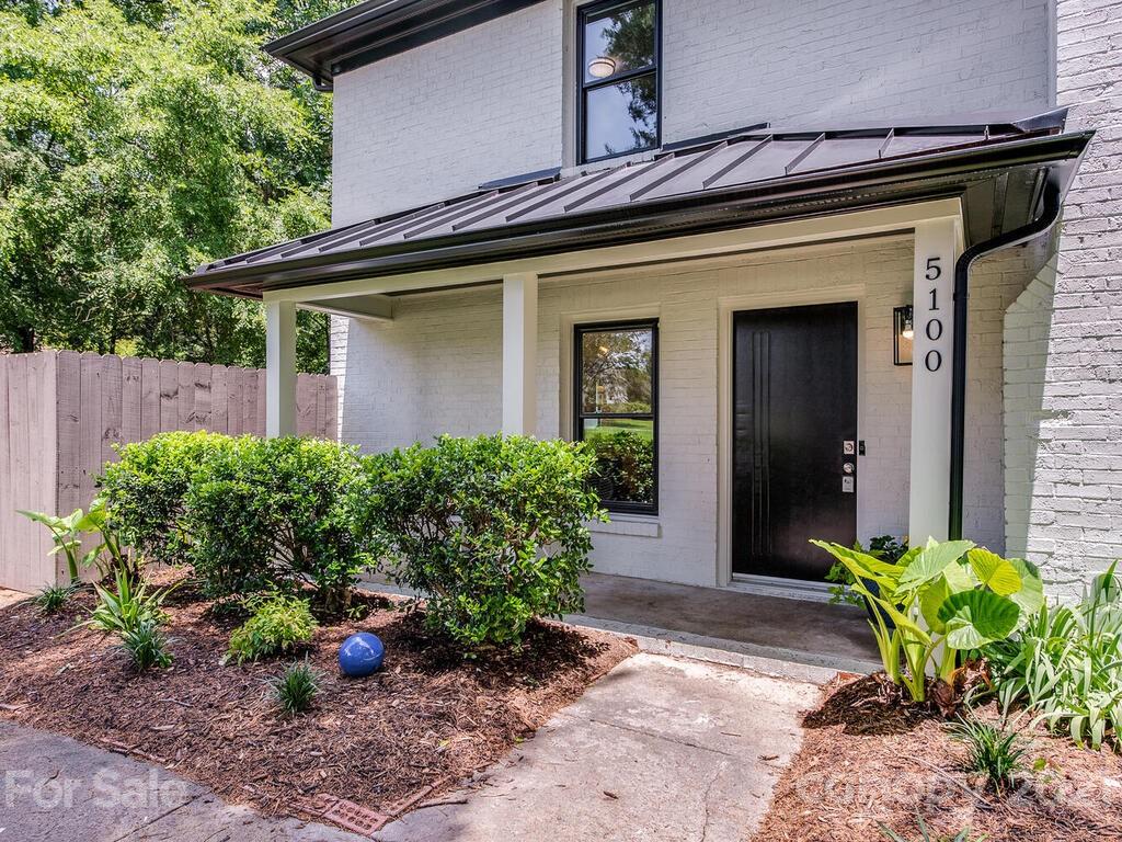 5024 Rea Road Charlotte, NC 28226 - Photo 3 of 19 a view of a house with potted plants and a table and chairs