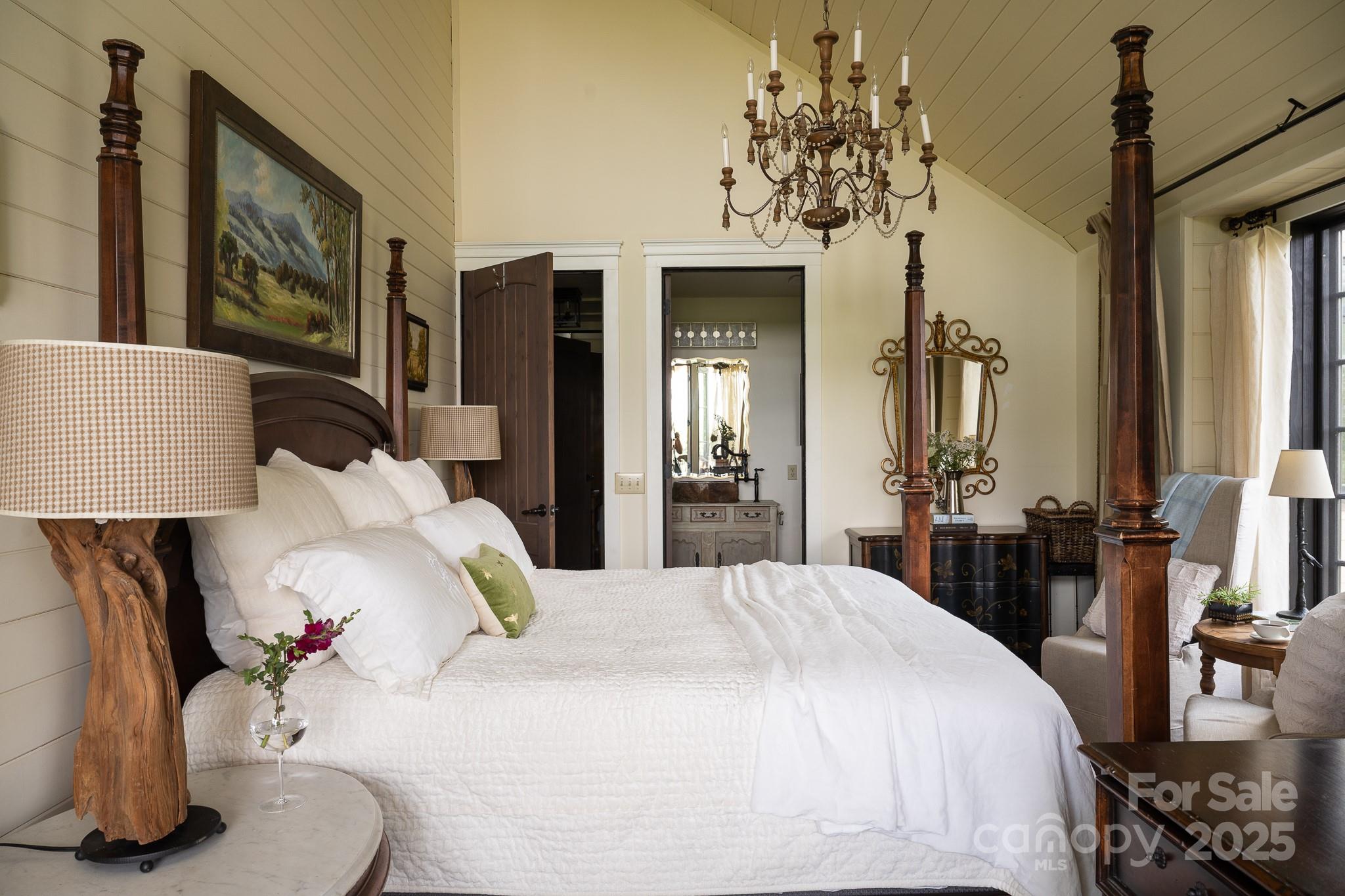 384 Doan Town Road Burnsville, NC 28714 - Photo 34 of 44 a bedroom with a bed and a chandelier