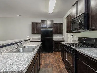 a kitchen with a stove and a wooden floors