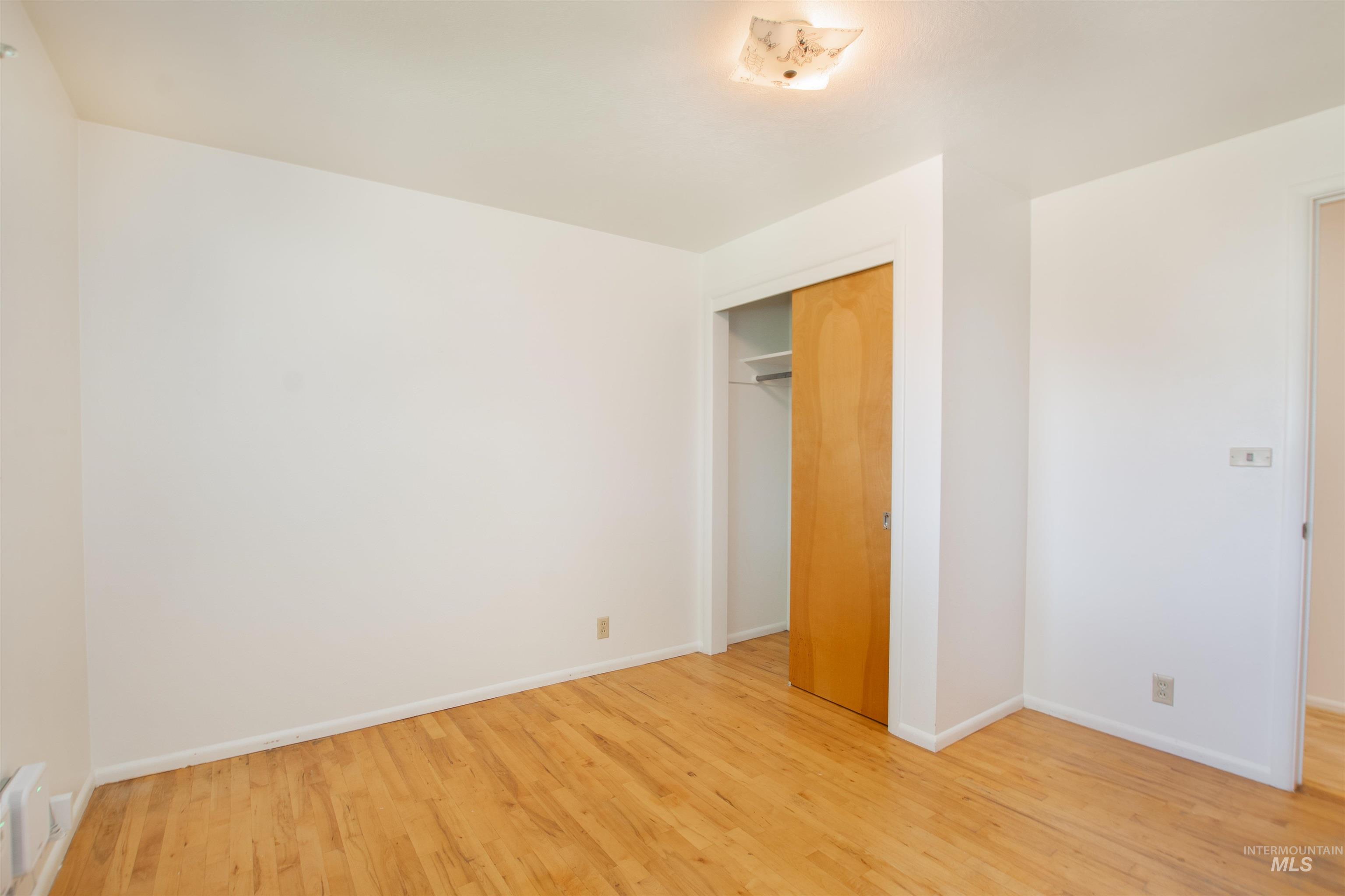 2716 North Redway Road Boise, ID 83704 - Photo 17 of 36 Hardwood-style flooring, neutral wall tones, flush-mount ceiling light, and built-in closet with wood-panel doors