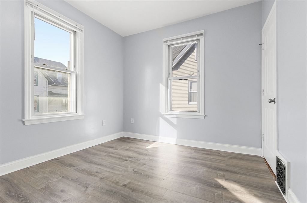 403 Ferry Street, Unit 2 Malden, MA 02148 - Photo 11 of 17 an empty room with wooden floor and windows