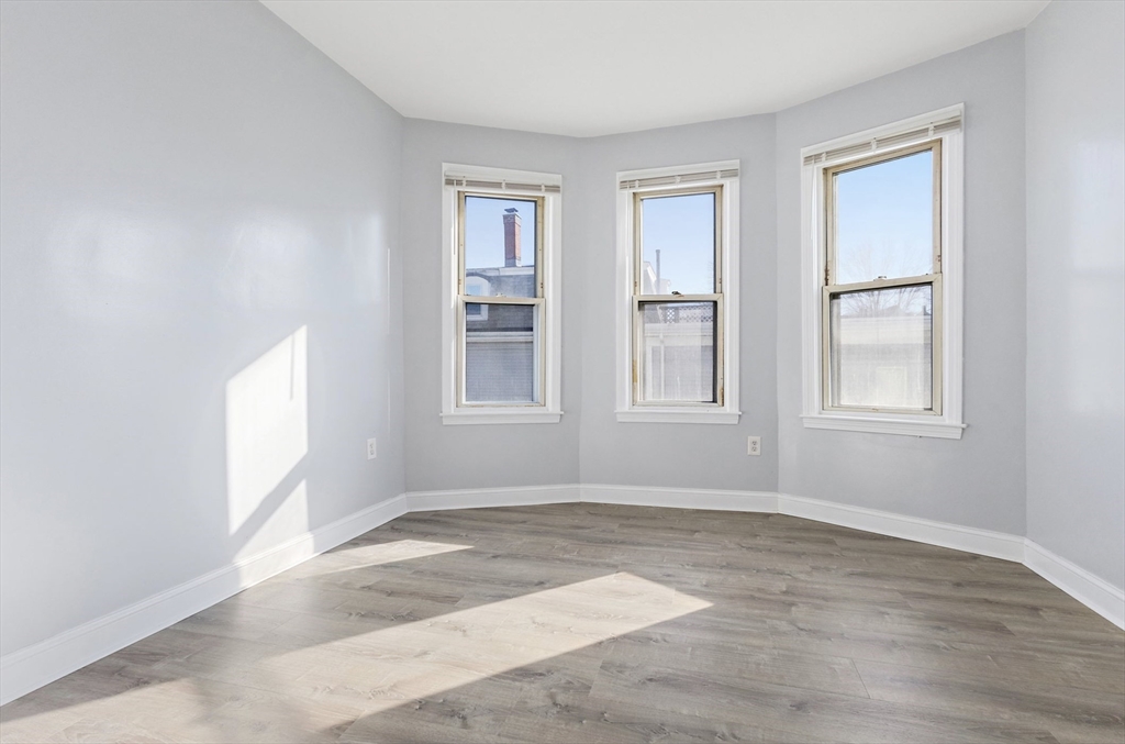 403 Ferry Street, Unit 2 Malden, MA 02148 - Photo 5 of 17 an empty room with wooden floor and windows