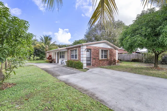 a front view of house with yard and trees around