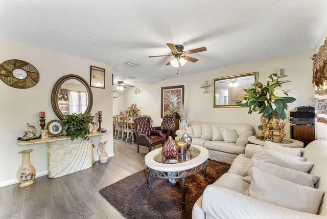 a living room with furniture a fireplace and a chandelier