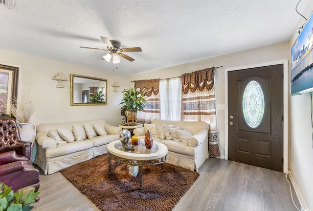 a living room with furniture a rug and white walls