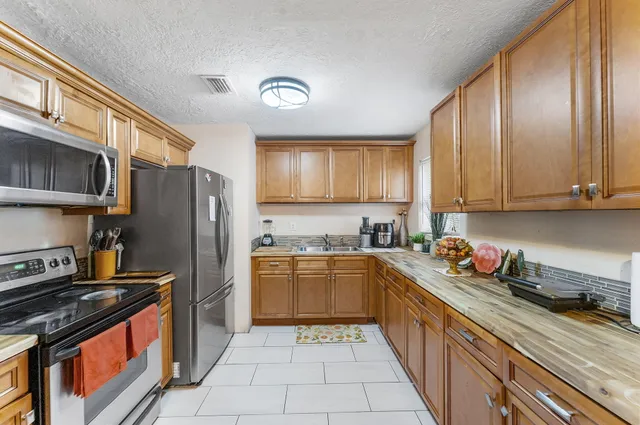 a kitchen with stainless steel appliances granite countertop a stove a sink dishwasher and a refrigerator