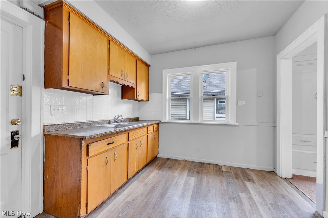 860 Greyton Road Cleveland Heights, OH 44112 - Photo 23 of 31 Kitchen featuring sink, light wood-type flooring, and tasteful backsplash