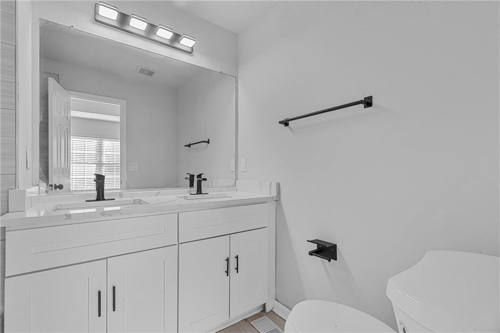 1731 Pryor Road Southwest, Unit 301 Atlanta, GA 30315 - Photo 19 of 29 a bathroom with a toilet a sink a mirror and vanity