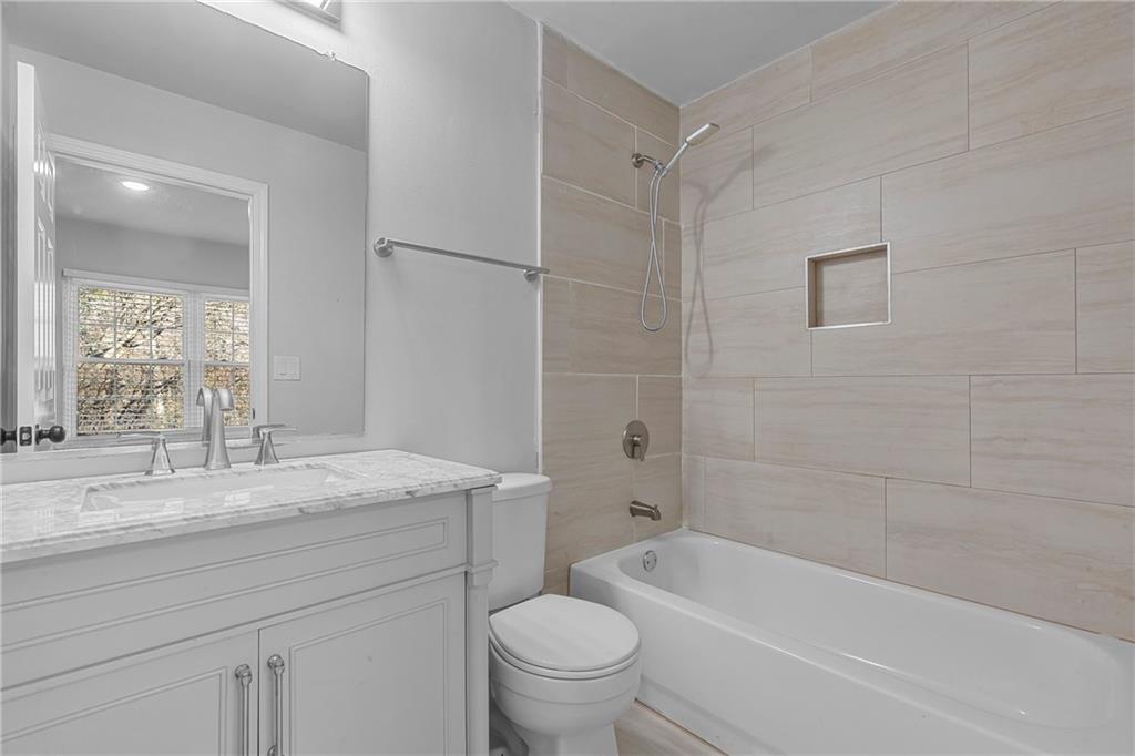 1731 Pryor Road Southwest, Unit 301 Atlanta, GA 30315 - Photo 22 of 29 a bathroom with a granite countertop sink a toilet and bathtub