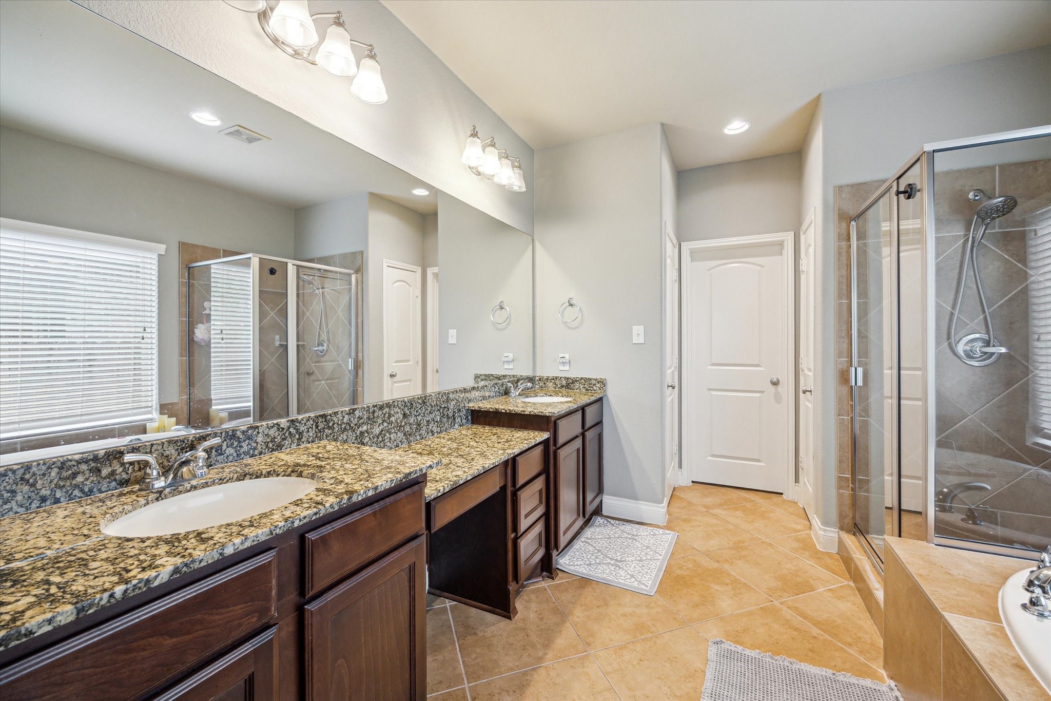 28919 Crested Butte Drive Katy, TX 77494 - Photo 22 of 36 The primary bathroom features tile floors, dual sinks, vanity area, walk-in shower, and separate tub.