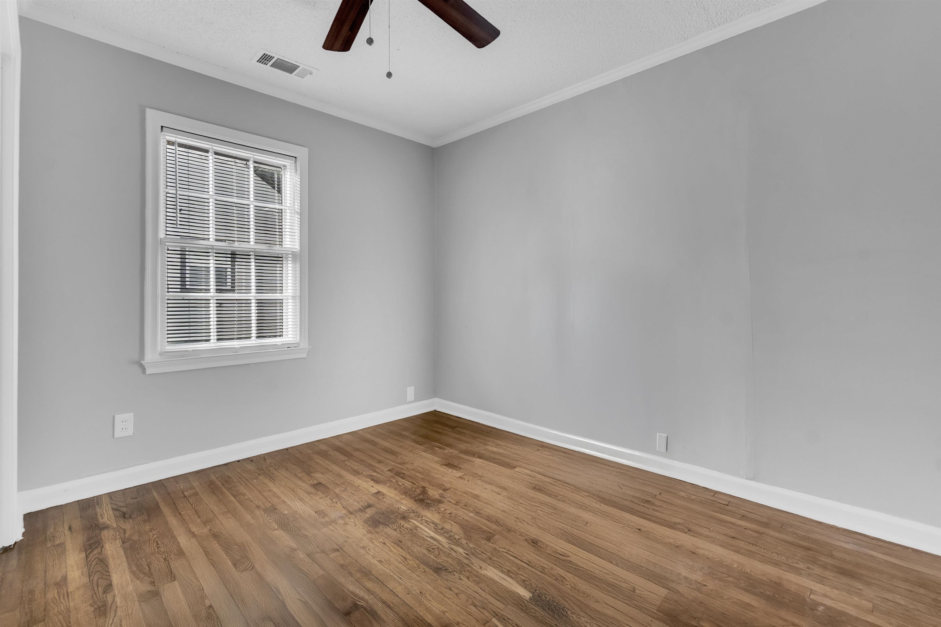 3844 Wilshire Road Memphis, TN 38111 - Photo 11 of 18 an empty room with wooden floor and windows