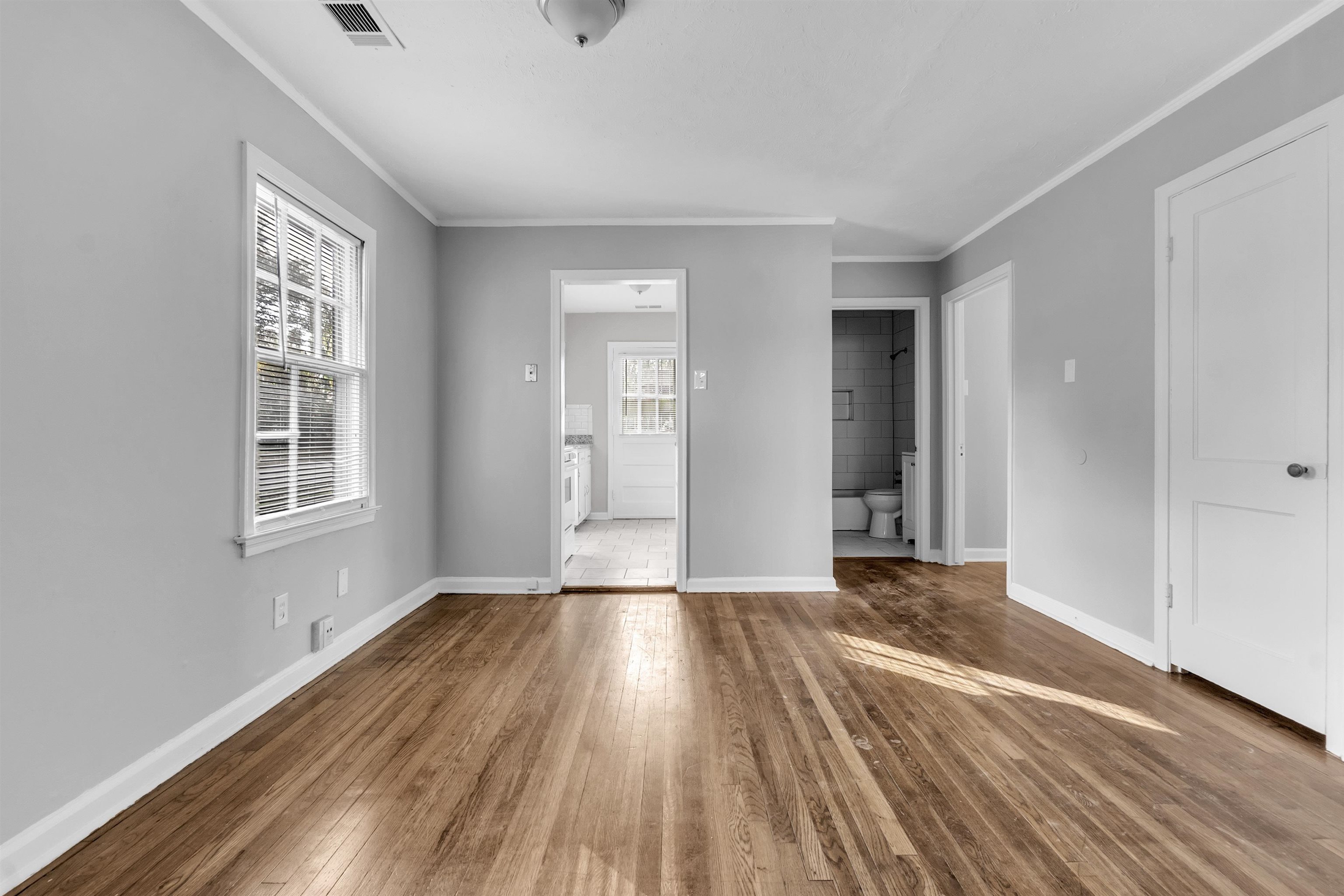 3844 Wilshire Road Memphis, TN 38111 - Photo 12 of 18 a view of an empty room with wooden floor and a window