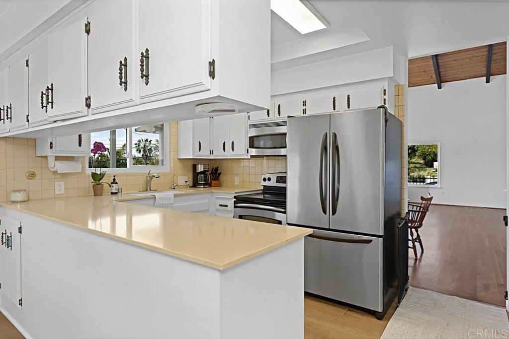 1551 Burgundy Road Encinitas, CA 92024 - Photo 11 of 31 a kitchen with stainless steel appliances a refrigerator sink and cabinets