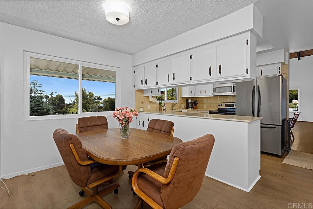 1551 Burgundy Road Encinitas, CA 92024 - Photo 13 of 31 a kitchen with stainless steel appliances granite countertop a stove a refrigerator a kitchen island a table and chairs