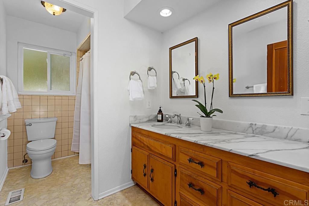 1551 Burgundy Road Encinitas, CA 92024 - Photo 17 of 31 a bathroom with a toilet sink and mirror