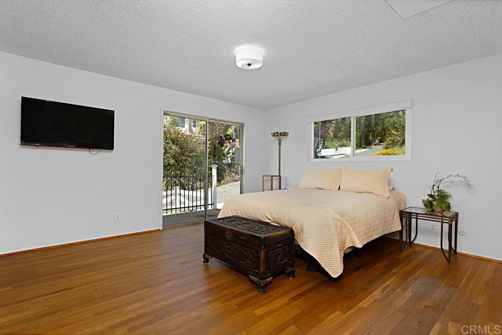 1551 Burgundy Road Encinitas, CA 92024 - Photo 18 of 31 a spacious bedroom with a bed and a flat screen tv