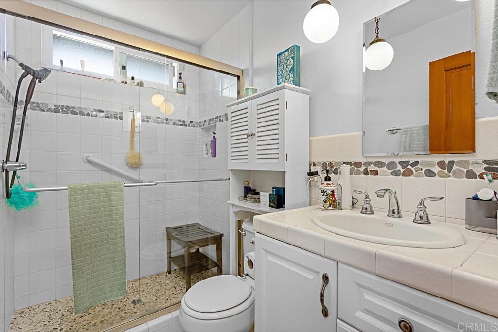 1551 Burgundy Road Encinitas, CA 92024 - Photo 26 of 31 a bathroom with a sink a toilet and mirror