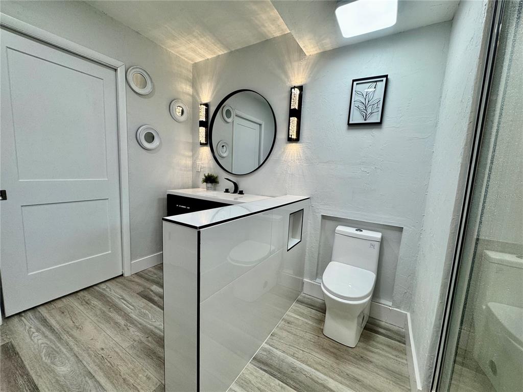 5407 Southwest 82 Terrace Gainesville, FL 32608 - Photo 18 of 31 a bathroom with a toilet a sink and mirror