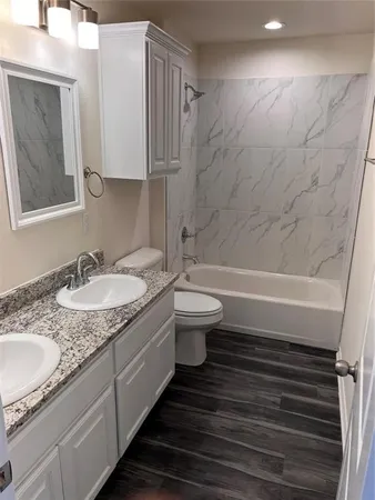 a bathroom with a granite countertop sink toilet and shower