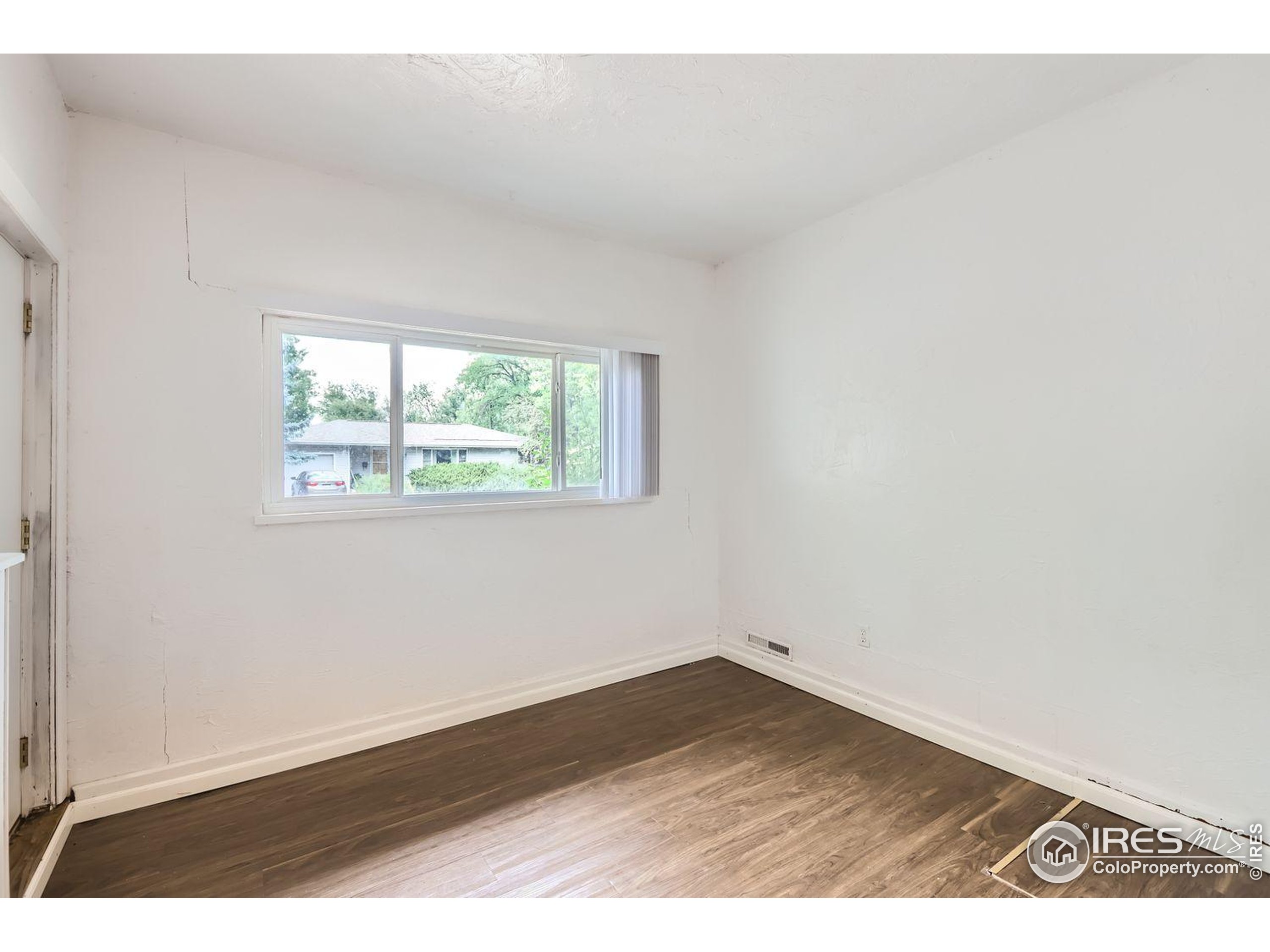 1517 Crestmore Place Fort Collins, CO 80521 - Photo 15 of 28 an empty room with wooden floor and windows
