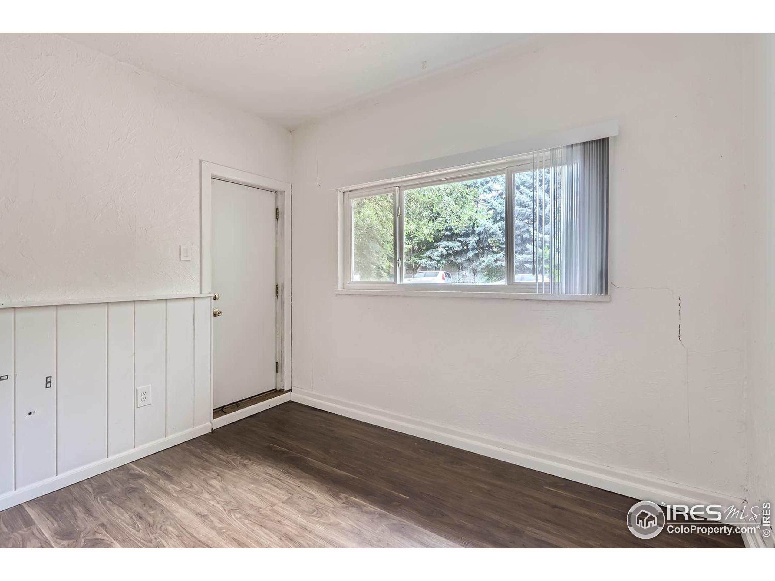 1517 Crestmore Place Fort Collins, CO 80521 - Photo 16 of 28 an empty room with wooden floor and windows