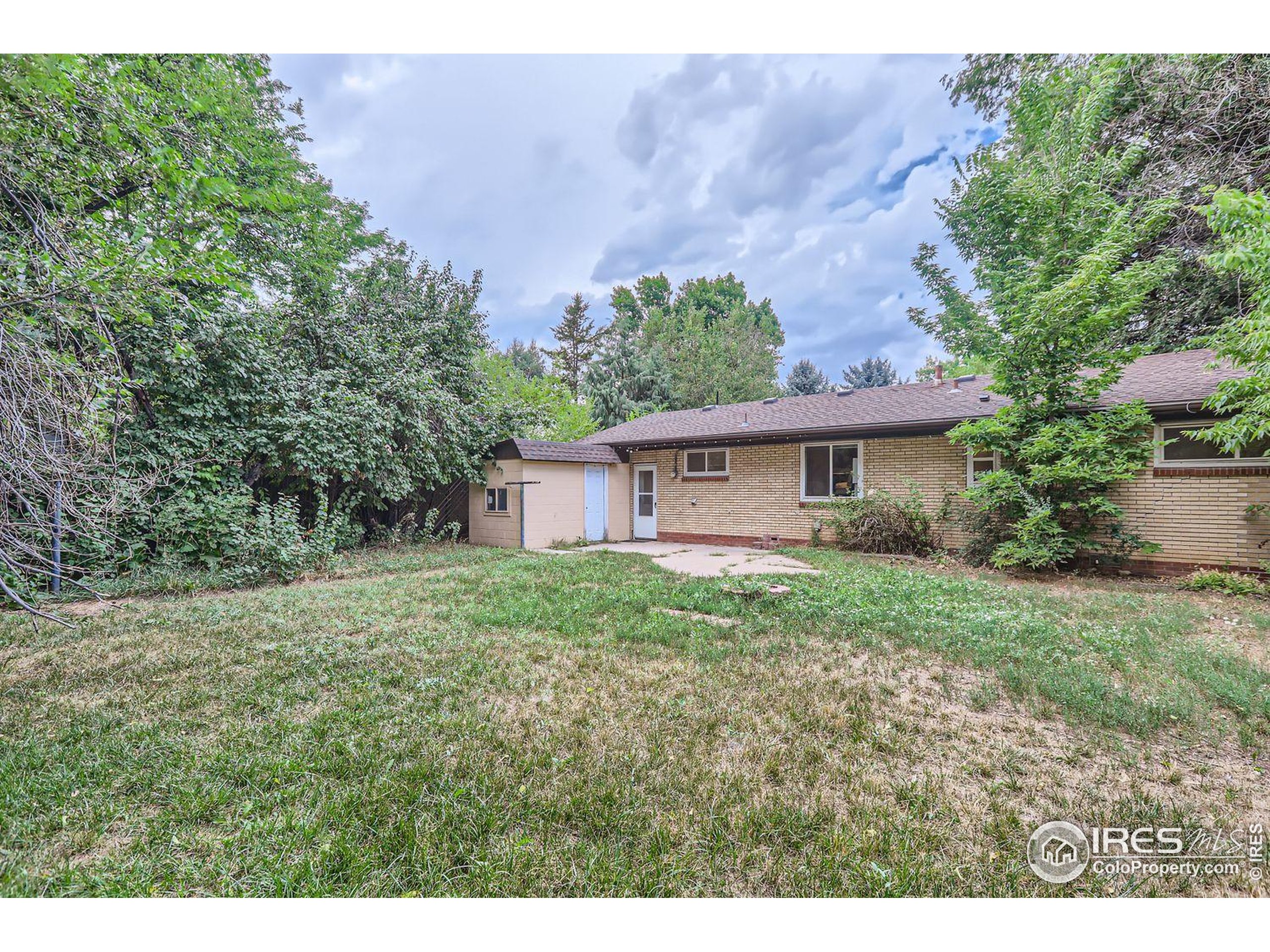 1517 Crestmore Place Fort Collins, CO 80521 - Photo 25 of 28 a view of a house with yard and a garden