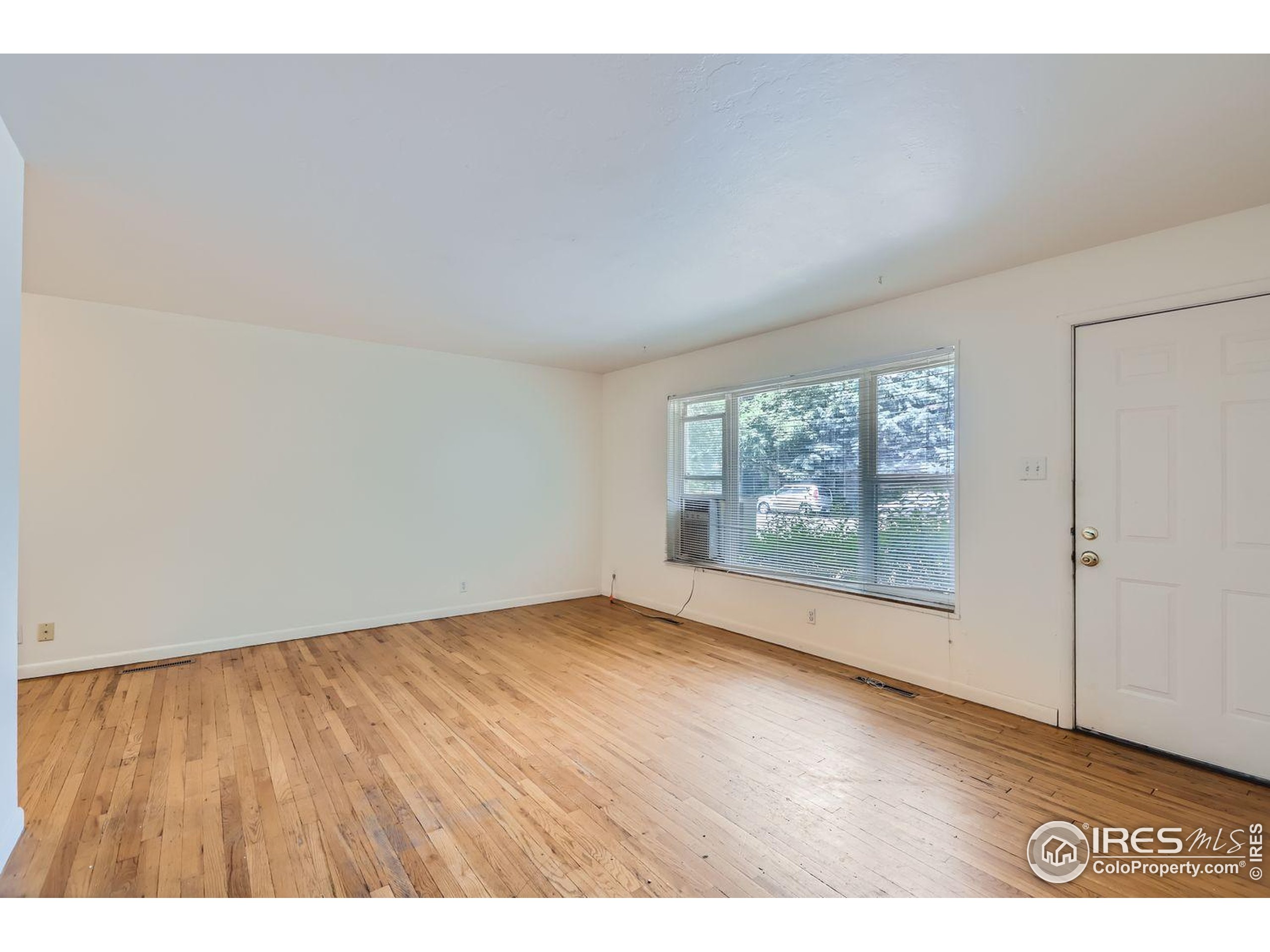 1517 Crestmore Place Fort Collins, CO 80521 - Photo 5 of 28 a view of an empty room with wooden floor and a window