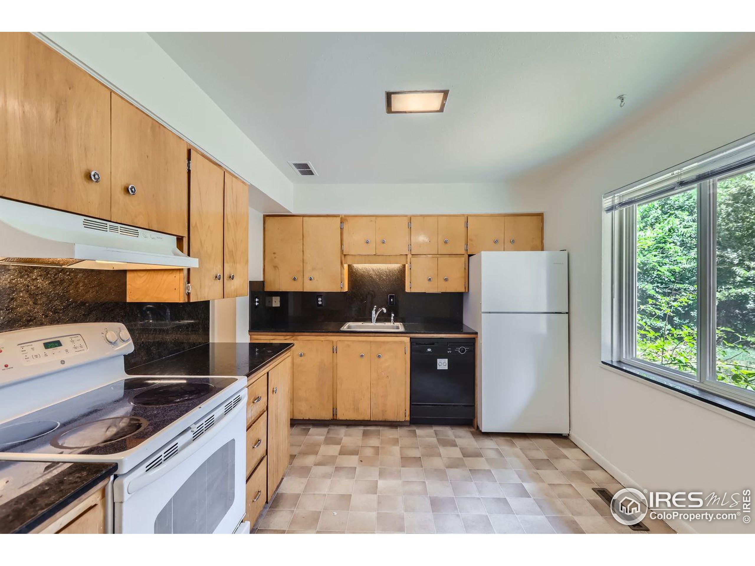 1517 Crestmore Place Fort Collins, CO 80521 - Photo 8 of 28 a kitchen with a refrigerator a stove a sink dishwasher and wooden cabinets with wooden floor