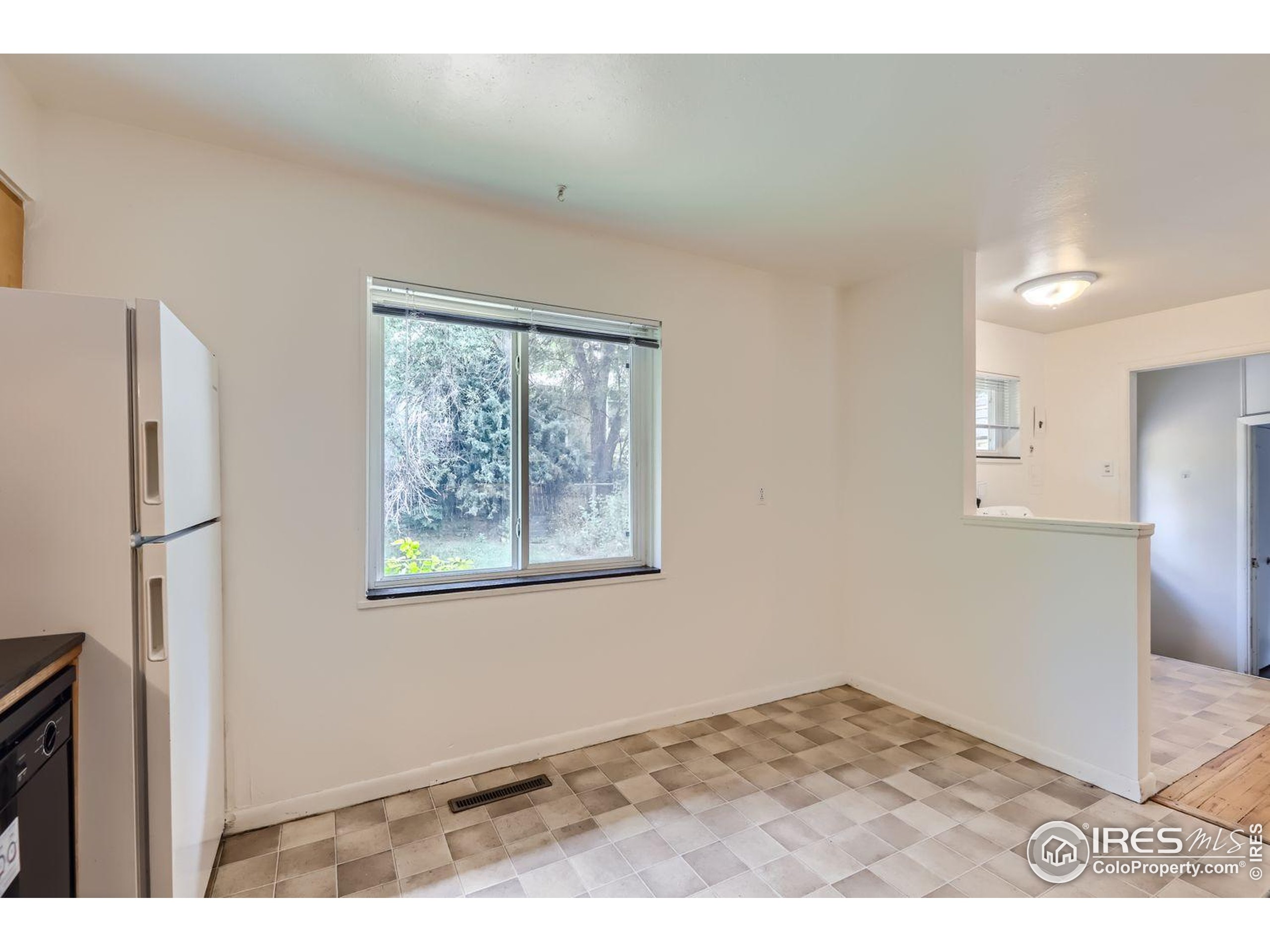 1517 Crestmore Place Fort Collins, CO 80521 - Photo 10 of 28 a view of an empty room with wooden floor and a window