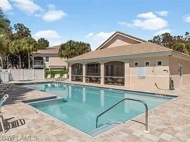 a view of a white house with a swimming pool and porch