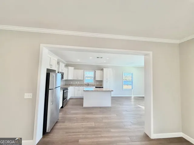 a kitchen with stainless steel appliances granite countertop a stove a sink and a microwave