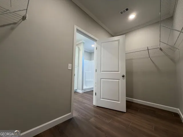 a view of a hallway with wooden floor and closet