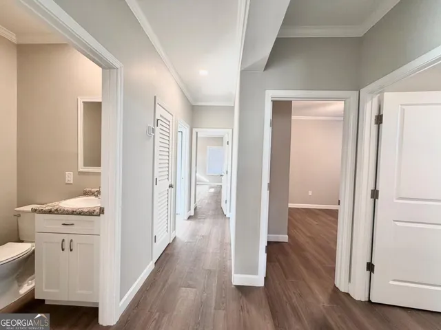 a bathroom with a toilet a sink and wooden floor